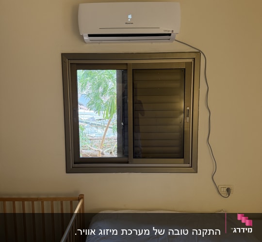מזגן מותקן מעל חלון בחדר שינה